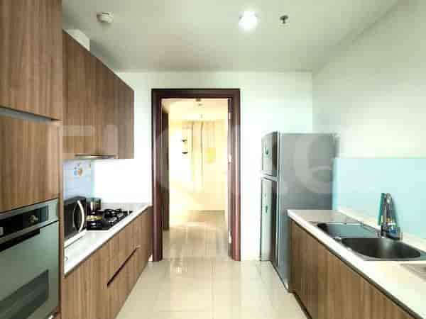 Dapur modern dengan lemari kayu, kompor gas, kulkas stainless steel, dan wastafel ganda.