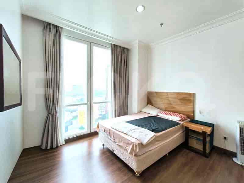 Kamar tidur dengan tempat tidur ukuran queen, kepala tempat tidur kayu, meja samping tempat tidur, dan jendela besar dengan tirai krem.