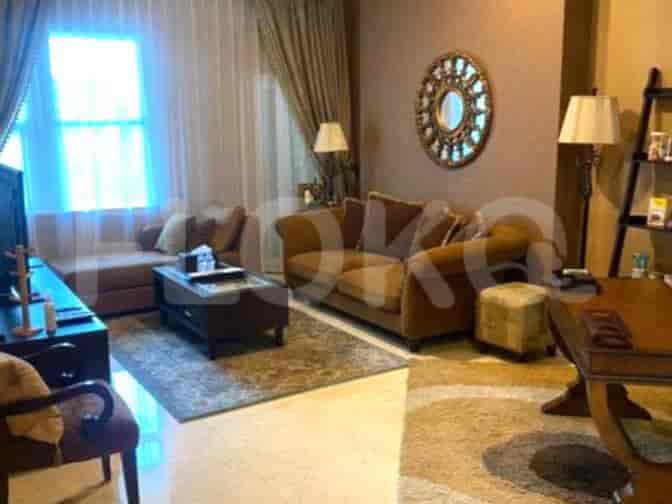 A well-lit living room with a plush brown sofa, a coffee table, and a decorative wall mirror.