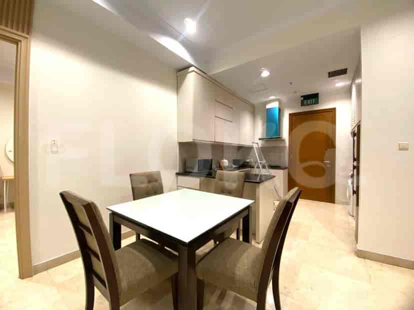 Area makan dengan meja dan kursi, berdekatan dengan dapur kecil.