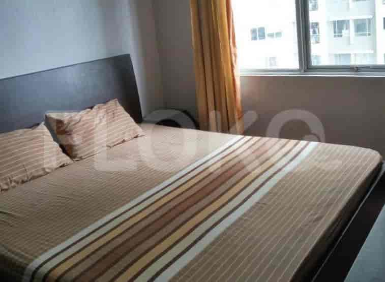 Kamar tidur yang nyaman dengan tempat tidur, meja samping tempat tidur, dan jendela.