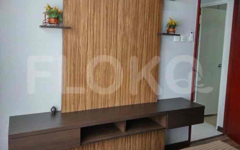 Ruang tamu dengan dinding panel kayu dan rak.