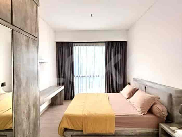 A bedroom with a king-size bed, a large window with dark curtains, and a built-in desk.