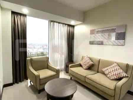 A living room with a sofa, armchair, and a coffee table, with large windows and curtains.