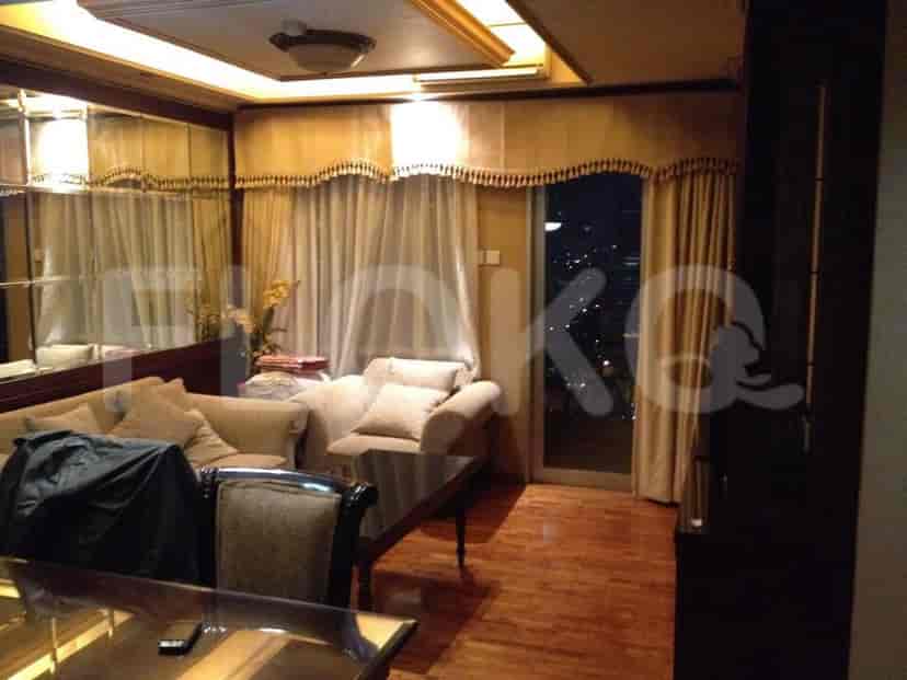 Ruang tamu dengan sofa, kursi, dan pemandangan kota.