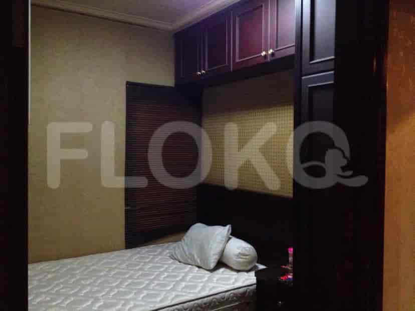 Kamar tidur dengan tempat tidur, lemari, dan meja samping.