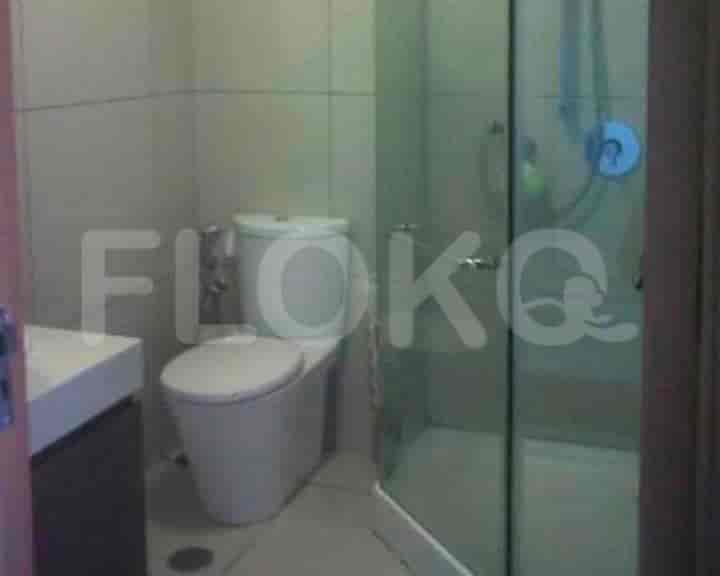 A small, modern bathroom with a shower and a toilet.