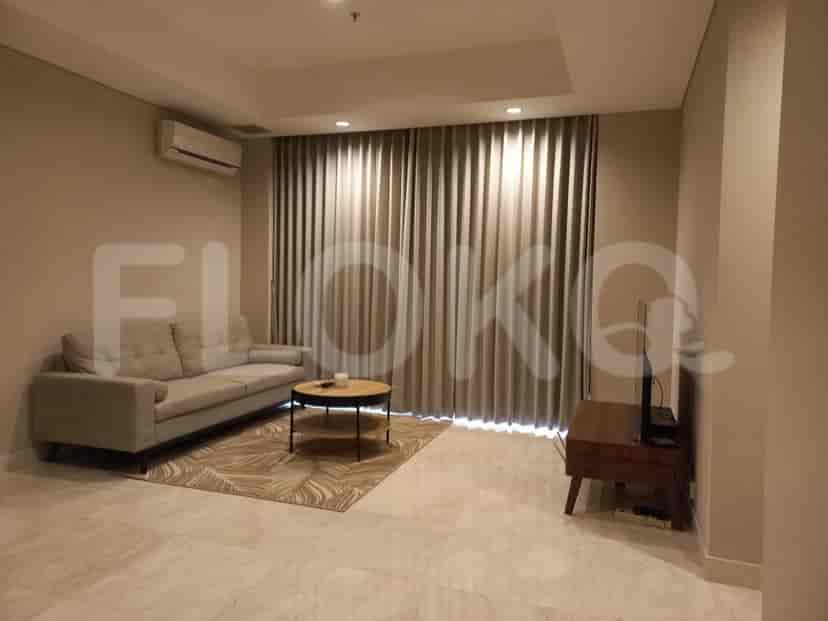Modern living room with grey sofa, coffee table, and entertainment unit.