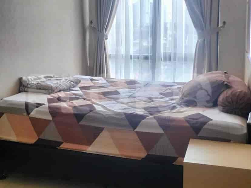 A bedroom with a queen-size bed, a patterned bedspread, and curtains covering a large window.