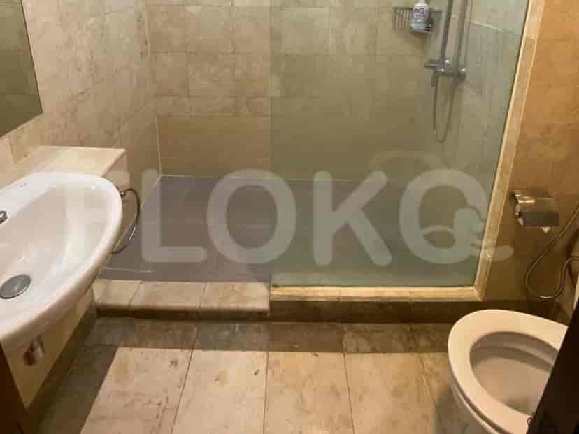 Bathroom with a white sink, shower, and marble tile.