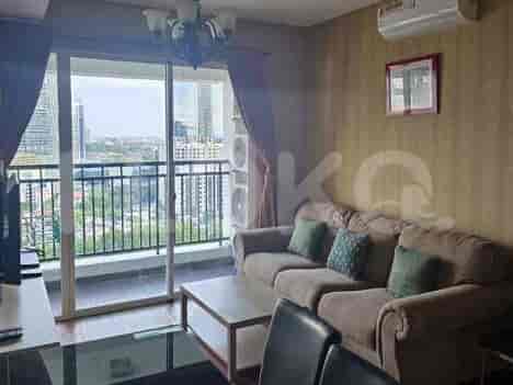 A living room with a large sofa, coffee table, and a balcony with a city view.