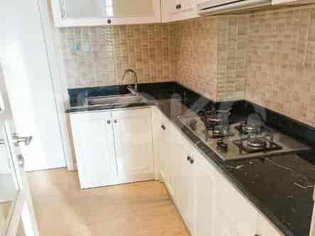 A compact kitchen with white cabinets, a granite countertop, and a gas stove.