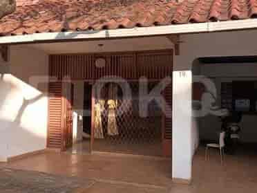 Pintu masuk utama rumah menampilkan pintu kayu dan jeruji besi dekoratif.