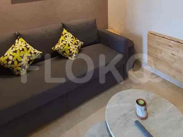 A cozy living area with a grey sofa, decorative cushions, and a marble coffee table.