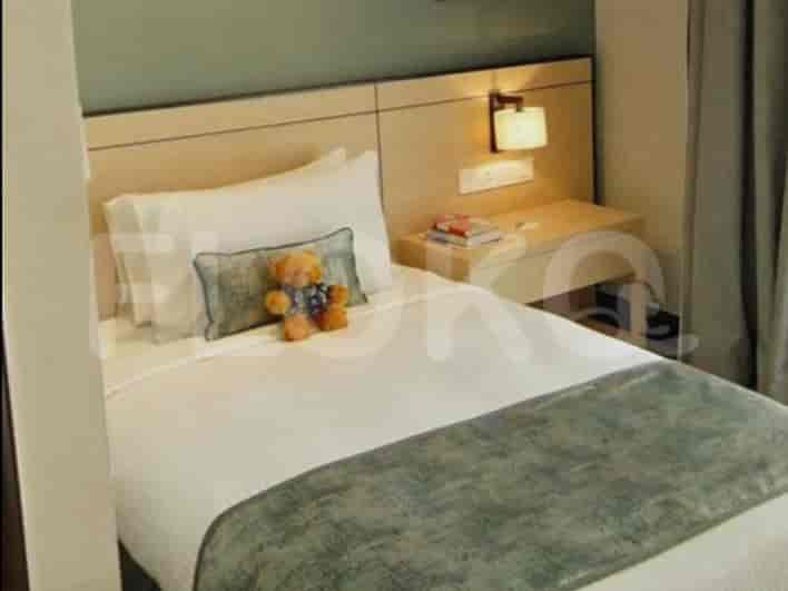 A bedroom with a single bed, nightstand, and lamp.