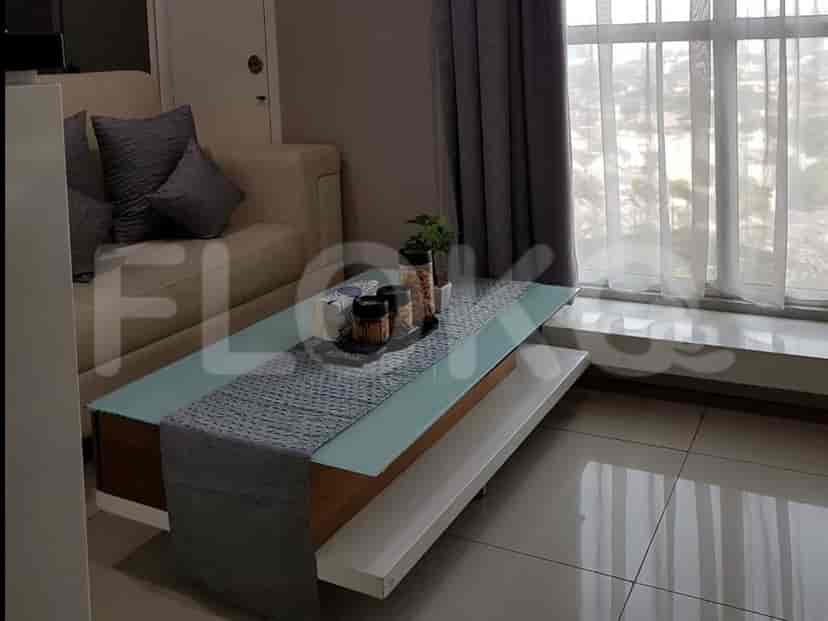 Living room featuring a coffee table, sofa, and a window with curtains.