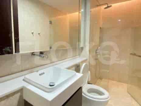 A contemporary bathroom with a vanity, sink, toilet, and a glass-enclosed shower.