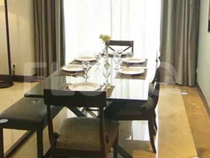 A dining area with a dark rectangular table, chairs, and place settings.