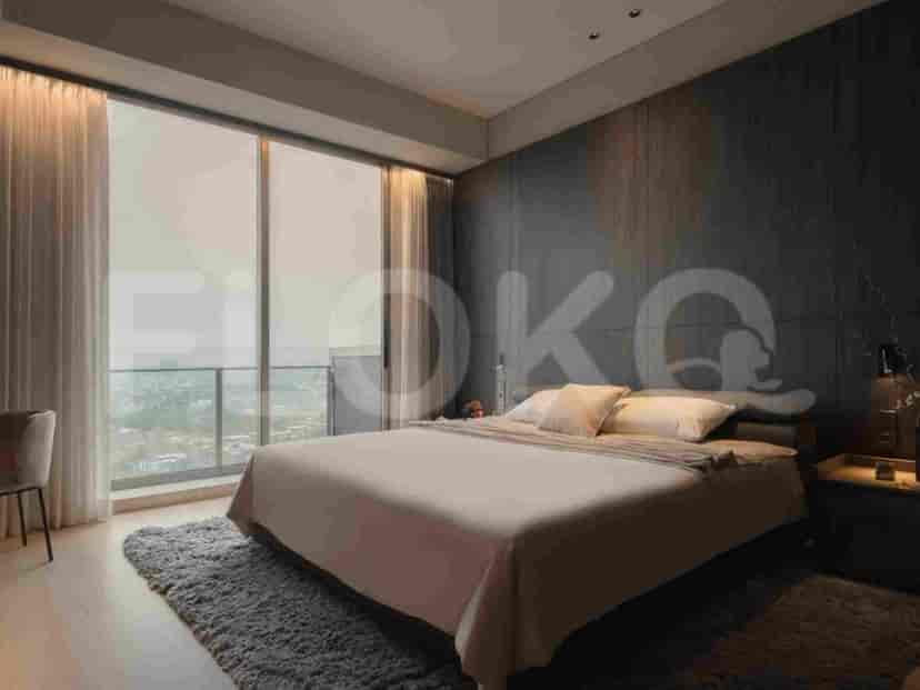 A bedroom with a large window offering a city view, a bed, and a nightstand.