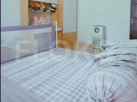 A child's bedroom with a bed, safety rail, and toys.