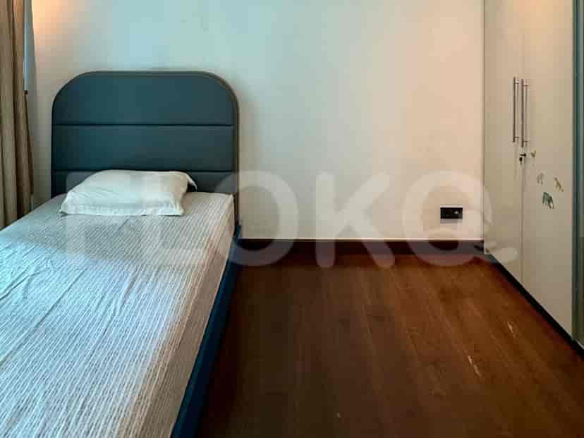 A bedroom with a single bed, a wardrobe, and wooden flooring.