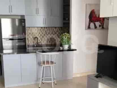 Modern kitchen with grey cabinets, a breakfast bar, and stainless steel appliances.