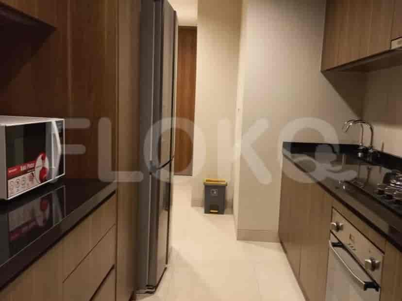 Kitchen with wooden cabinets, a microwave, and a refrigerator.