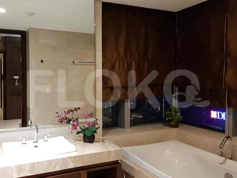 A luxurious bathroom with a double vanity, large bathtub, and a window with a city view.
