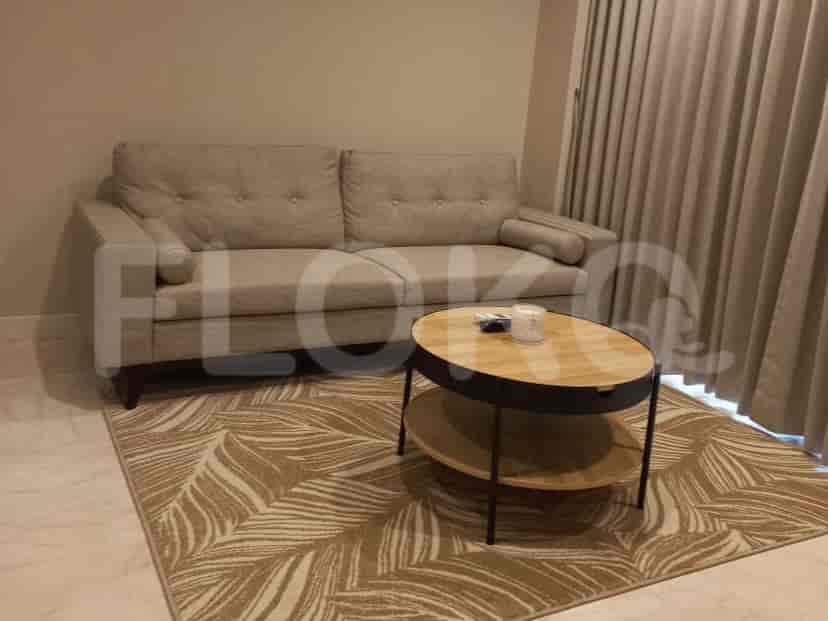 Living room featuring a beige sofa, patterned rug, and wooden coffee table.