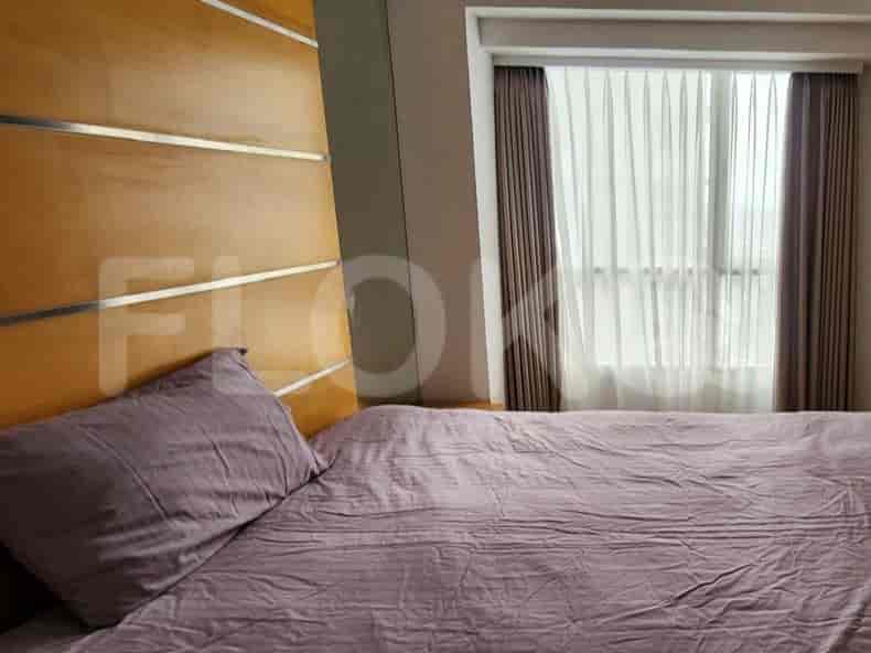 A bedroom with a bed and a window with curtains.