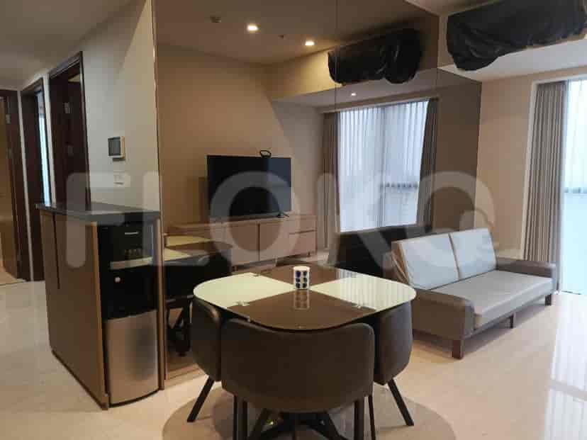 Area tamu dan makan gabungan dengan sofa, konsol TV, meja makan dengan kursi, dan dispenser air.