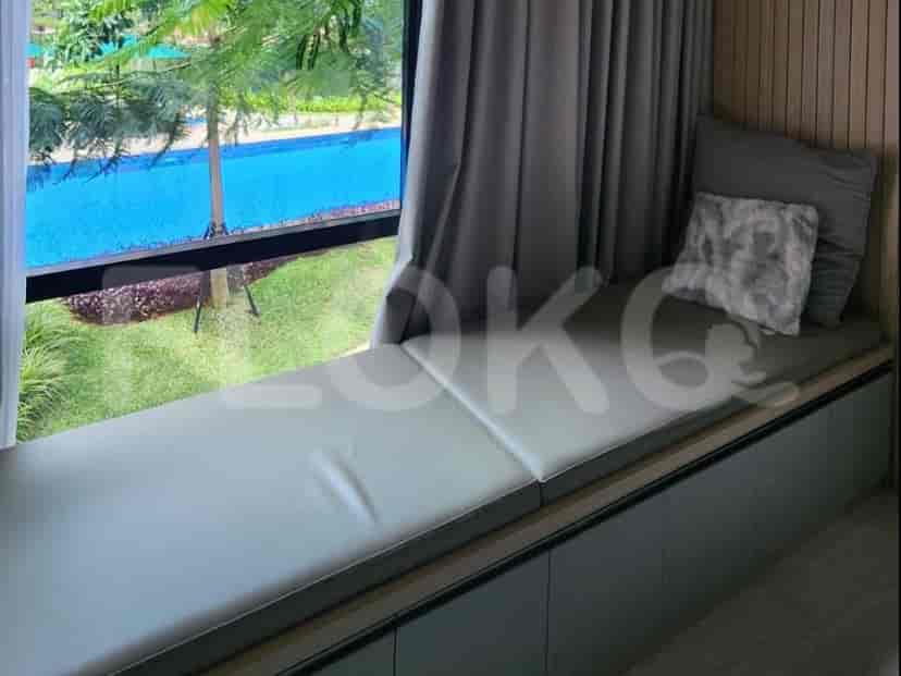 Tempat duduk dekat jendela dengan bantalan abu-abu menawarkan pemandangan yang santai.
