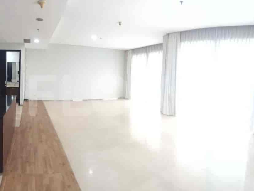 Living room with light-colored flooring and large windows.