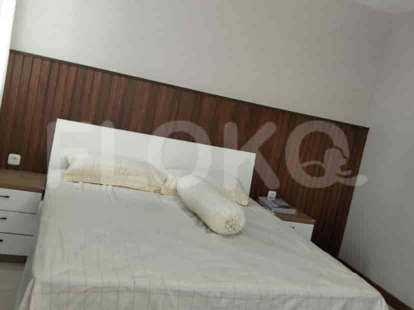 A bedroom with a large bed, nightstands, and a distinctive wooden headboard.