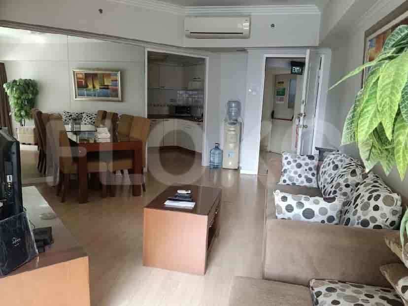 A combined living and dining area with a large mirrored wall, a dining set, a sofa, and a water dispenser.