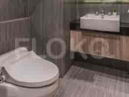 A modern bathroom with a toilet, a vanity with a sink, and tiled walls.