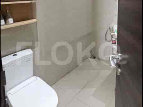 Kamar mandi ringkas dengan toilet dan shower kecil.