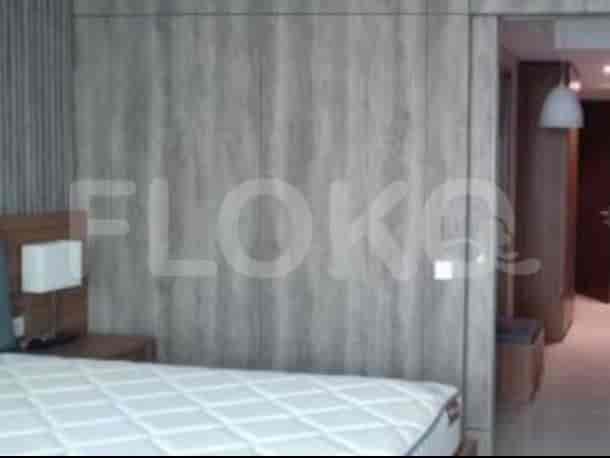 Bedroom scene with wooden paneling and a bed.