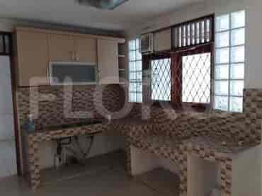 Dapur fungsional dengan meja dapur keramik, lemari kayu, dan wastafel.