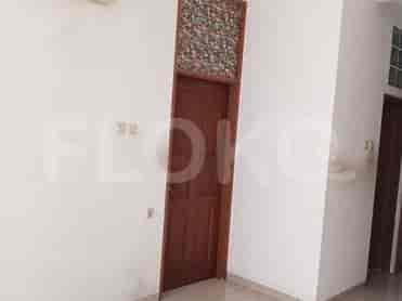 Tampilan interior sebuah pintu dengan pintu kayu dan panel dekoratif di atasnya.
