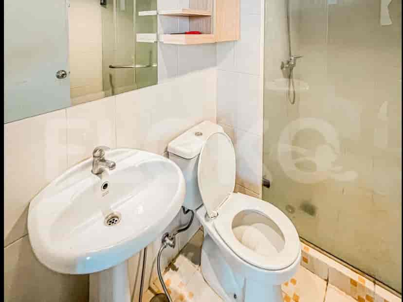 Kamar mandi dengan wastafel putih, toilet, dan pancuran.