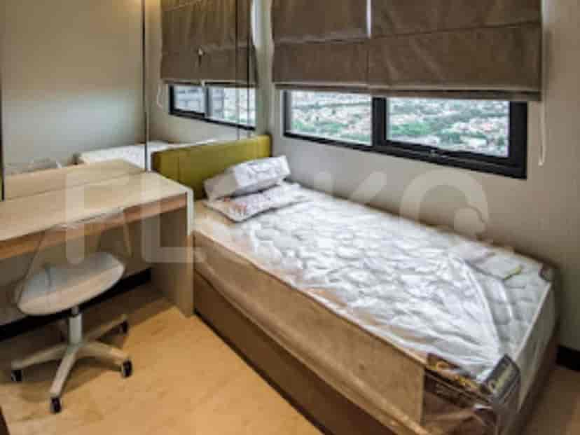 A small bedroom with a single bed, desk, and chair by the window.