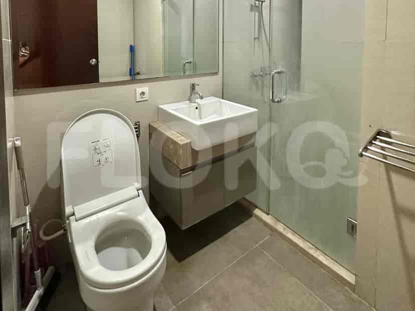 A modern bathroom with a glass shower enclosure and a toilet.