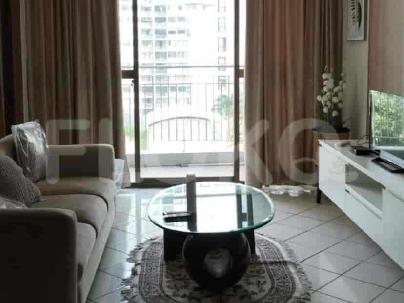 A living room with a sofa, coffee table, and a television.