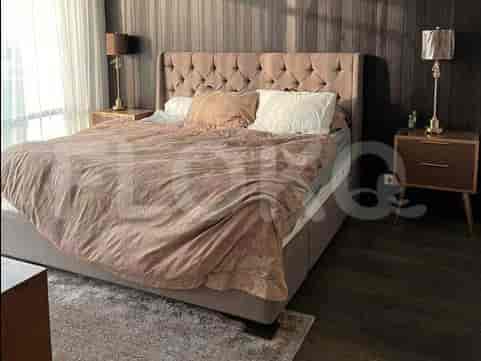 A king-sized bed with a tufted headboard, dressed in soft, patterned bedding, flanked by nightstands.