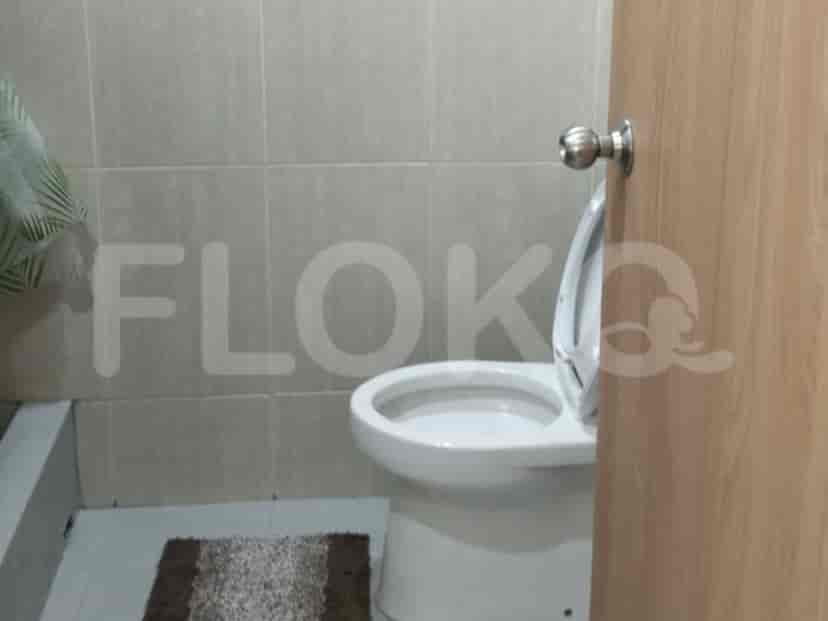 A toilet in a tiled bathroom.