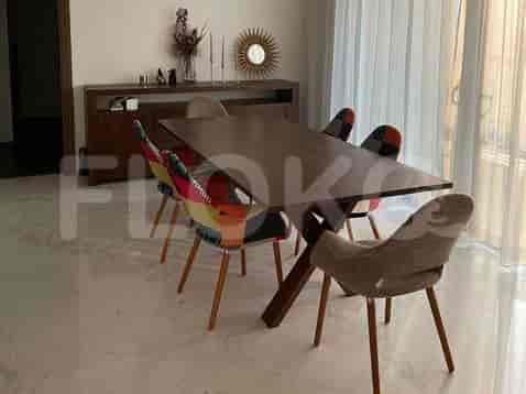 A dining area with a dark wooden table and chairs featuring colorful patchwork upholstery.