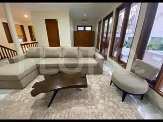 A spacious living room with an L-shaped grey sofa, coffee table, and large window.