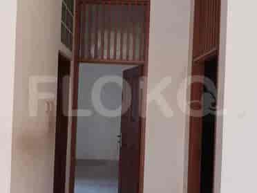 Pemandangan ke dalam interior rumah, menunjukkan sebuah pintu dan lantai keramik.