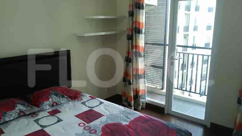 A bedroom with a bed, curtains, and a balcony.
